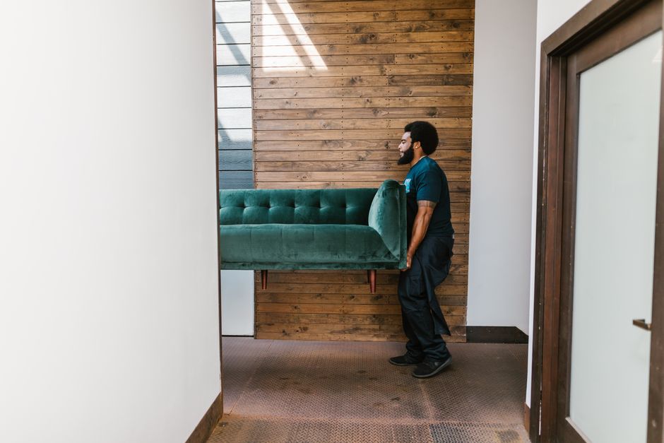 Movers carefully carrying a heavy sofa